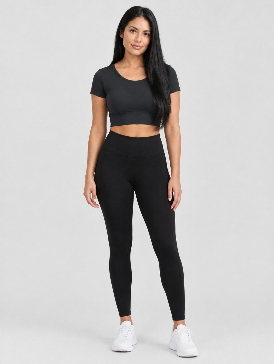 Woman wearing a black short sleeve cropped workout top with leggings, front view