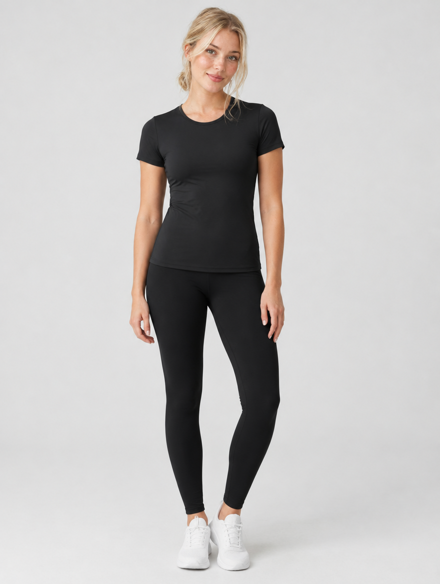 Woman wearing a black short sleeve fitted workout top with leggings, front view