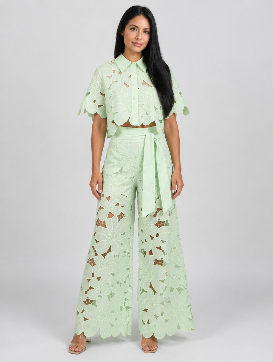 Woman wearing a mint green lace blouse and wide leg lace trousers set with tie waist, front view