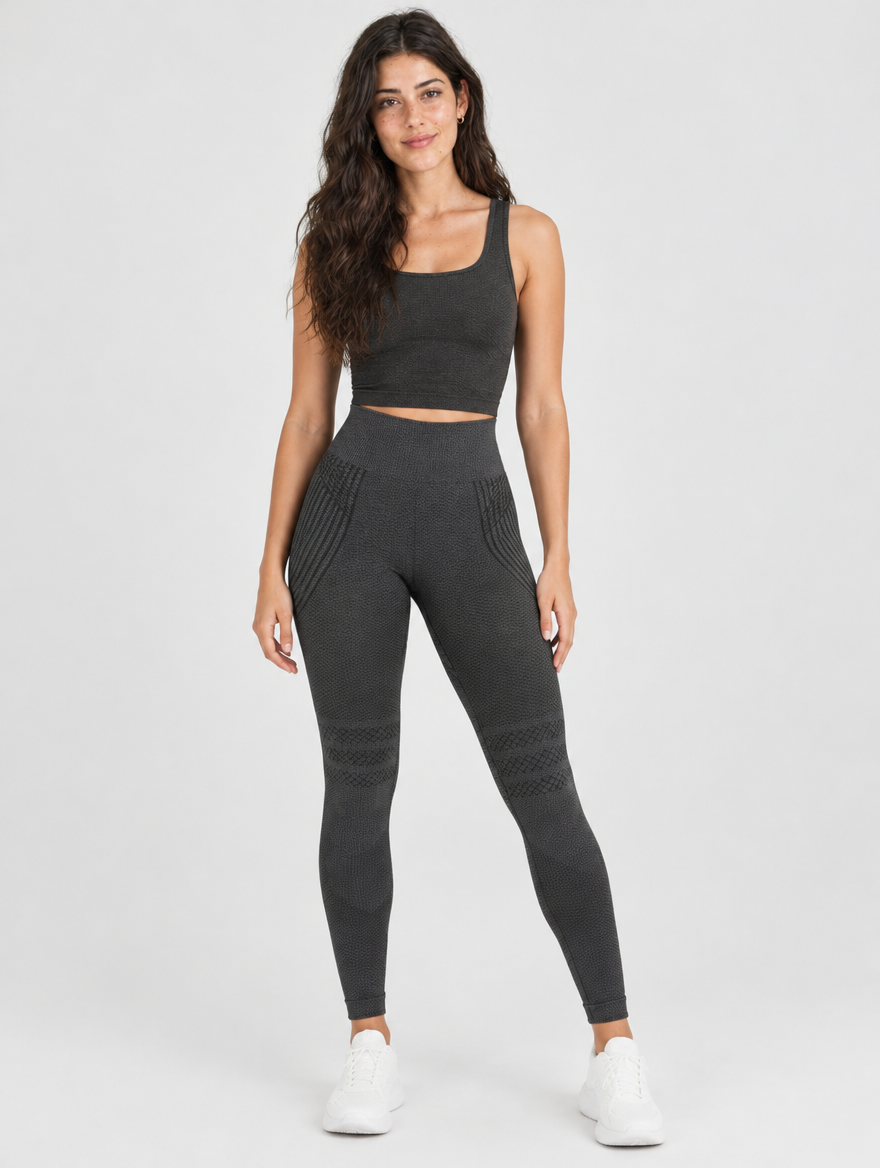 Woman wearing dark grey high-waisted gym leggings with matching sports top, front view