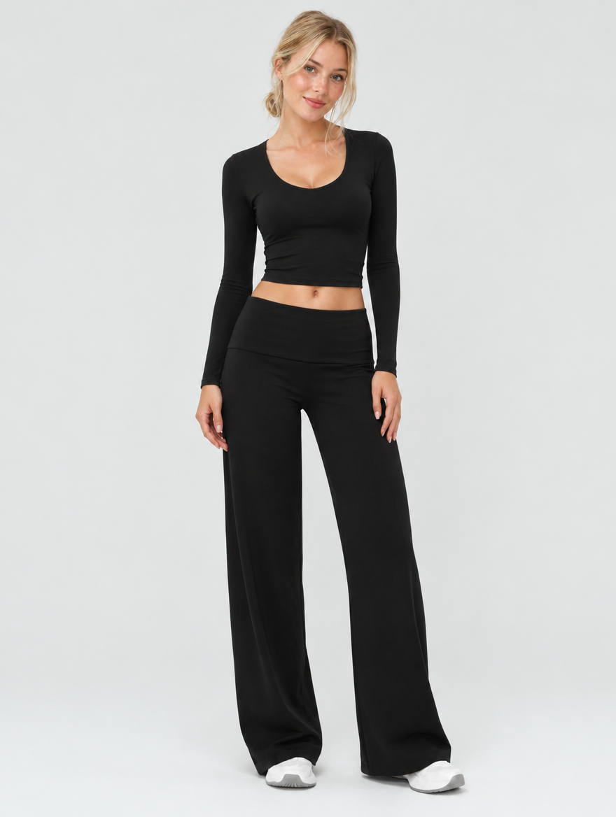 Woman wearing a black two-piece yoga set with long sleeve top and wide-leg pants, front view