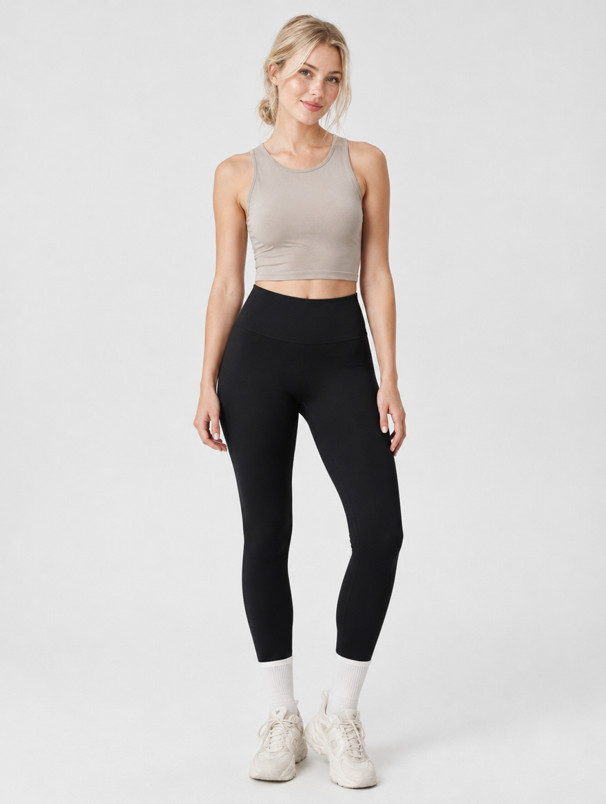Woman wearing black high-waisted gym leggings with wide waistband, front view