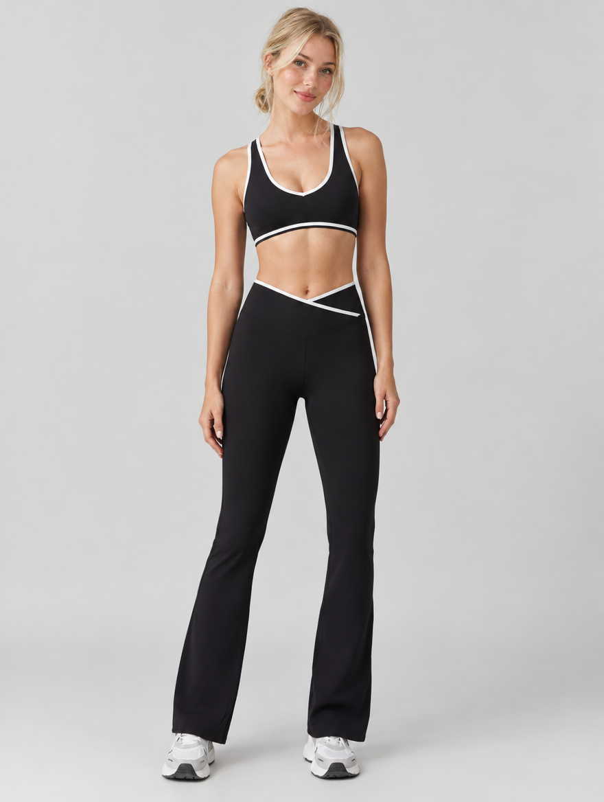 Woman wearing a black yoga set with sports bra and flare leggings with white trim, front view
