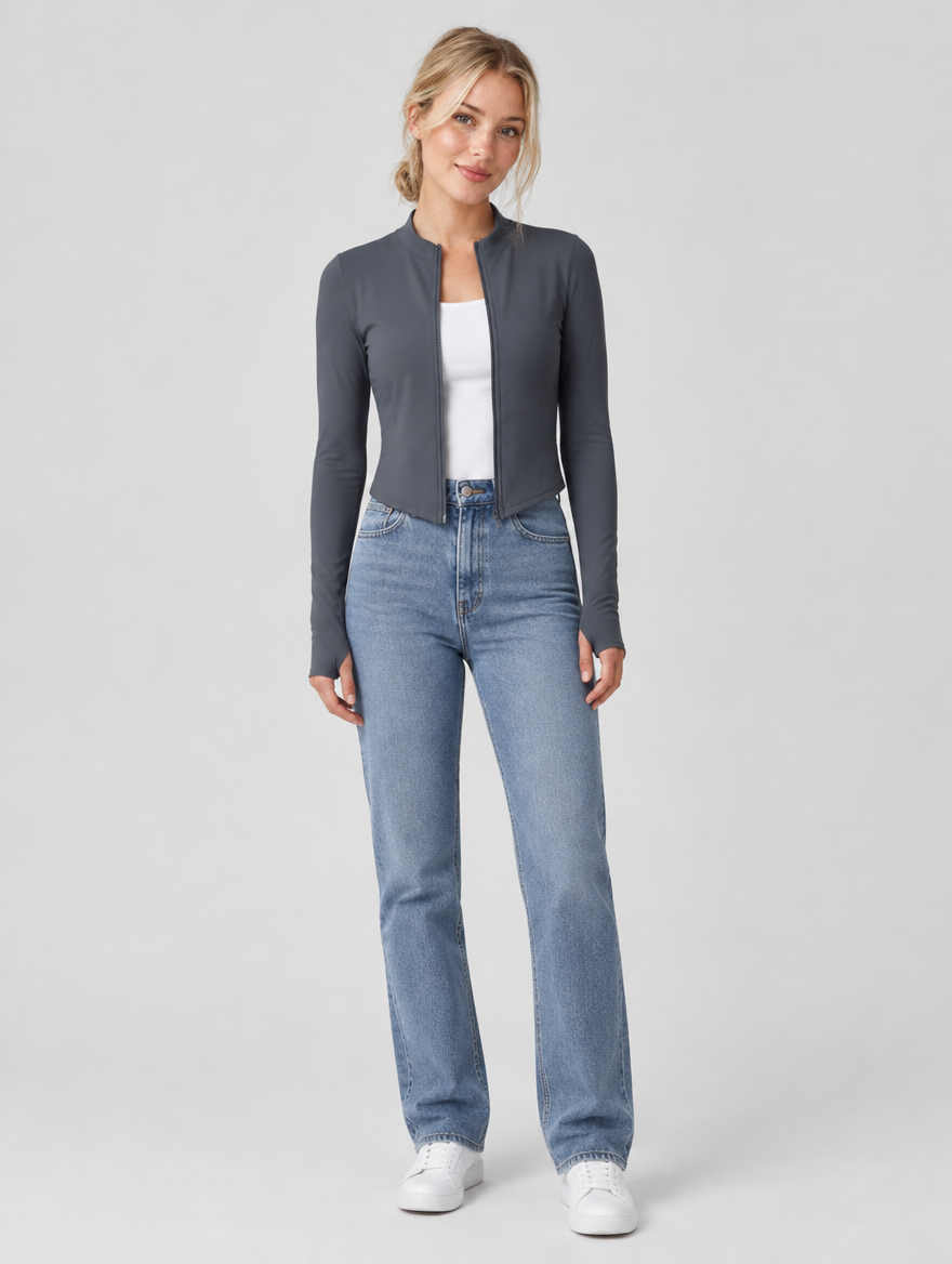Woman wearing a grey fitted zip jacket with jeans, front view